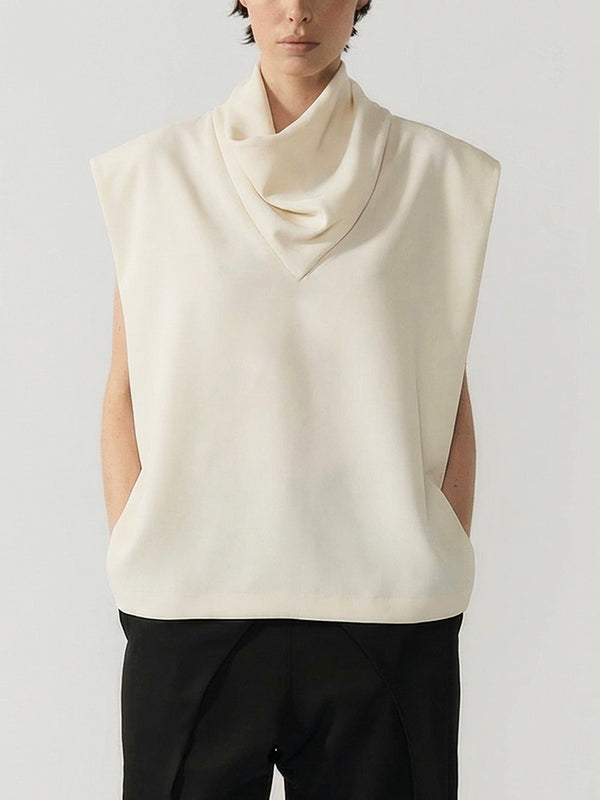 #off-white Person wearing a cream sleeveless top with a cowl neck on a plain background