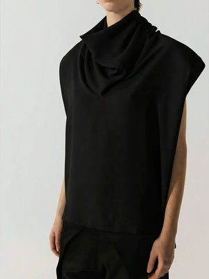 #black Person wearing a black sleeveless top with a draped design on a plain background