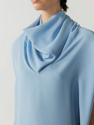 #sky-blue Light blue scarf draped around a person's neck on a plain background