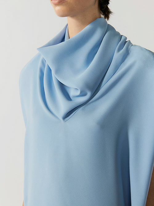#sky-blue Light blue scarf draped around a person's neck on a plain background