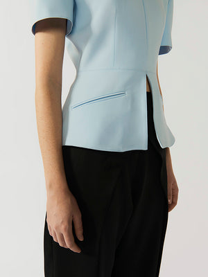 #sky-blue Light blue top worn by a person on a white background
