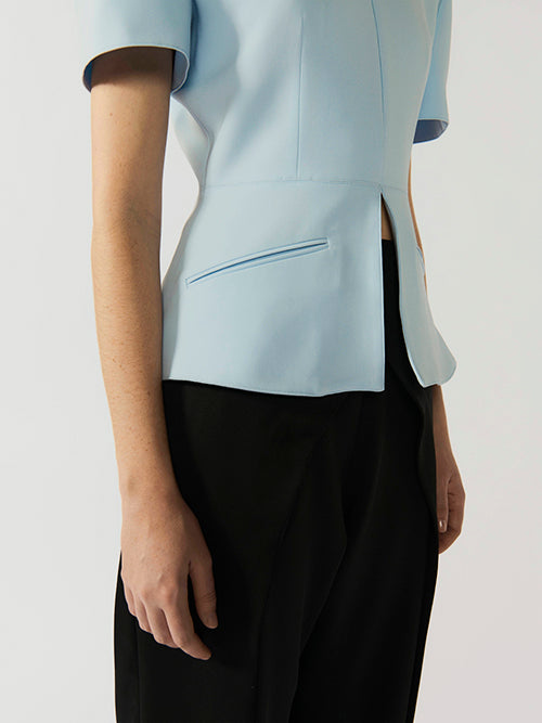 #sky-blue Light blue top worn by a person on a white background