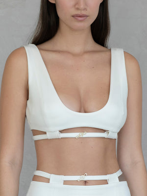 #off-white Woman wearing a white bikini top against a gray background