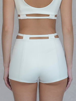 #off-white Person wearing a white crop top and shorts on a plain background