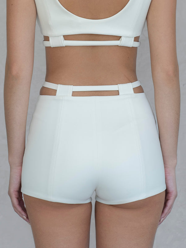 #off-white Person wearing a white crop top and shorts on a plain background