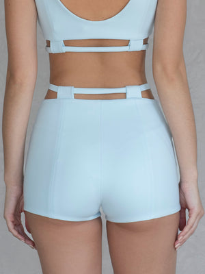 #sky-blue Person wearing a white sports bra and shorts set on a neutral background