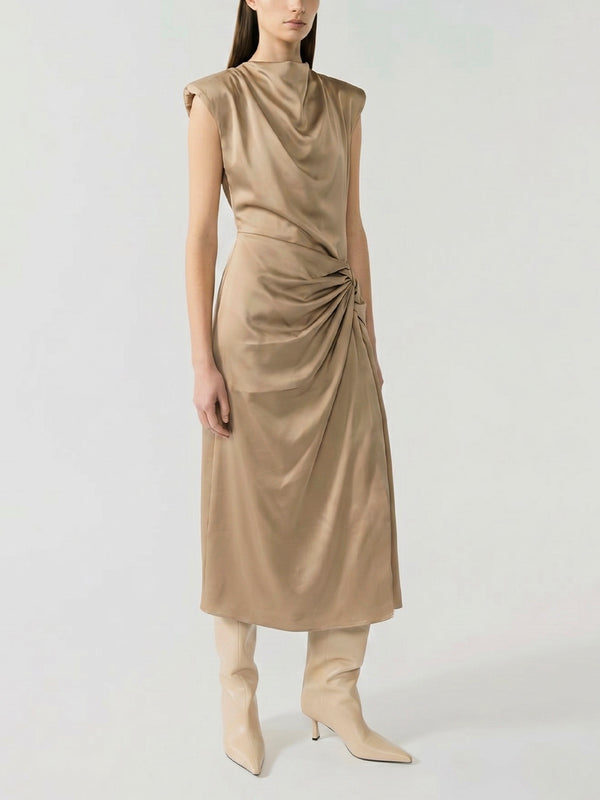 #sand Woman wearing a beige sleeveless dress with a draped design on a white background