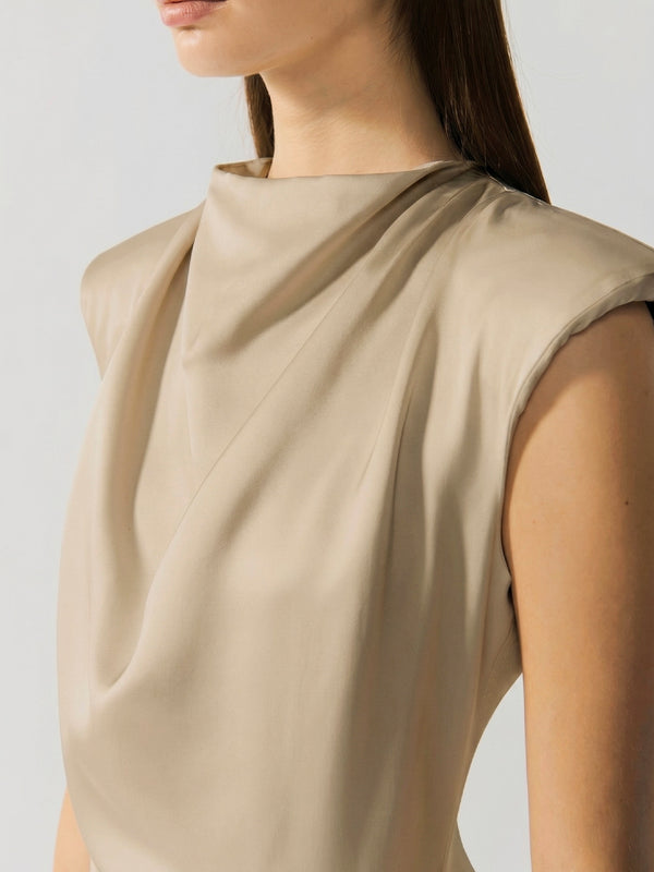 #sand Beige sleeveless top worn by a person on a light gray background
