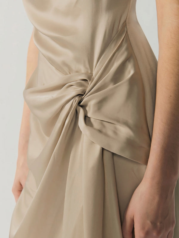 #sand Beige satin dress with a knot detail on a plain background
